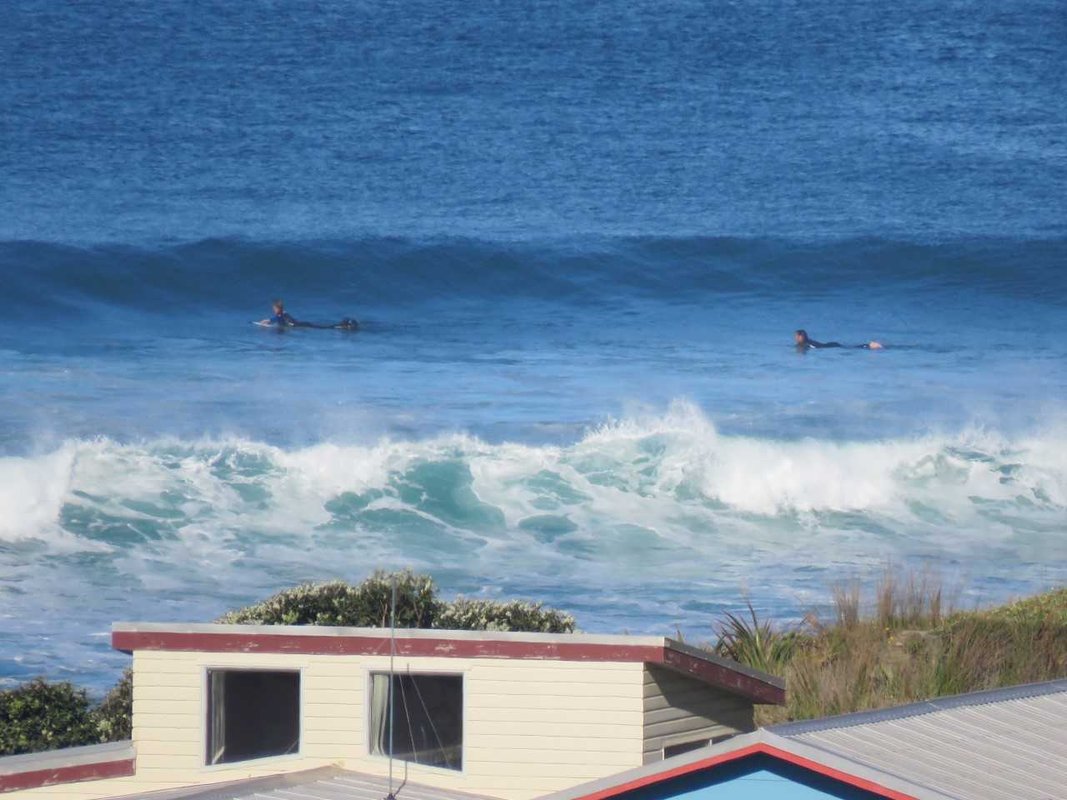 Paddling out the back on a bigger day, Baylys Beach surf spot, Northland West, New Zealand.